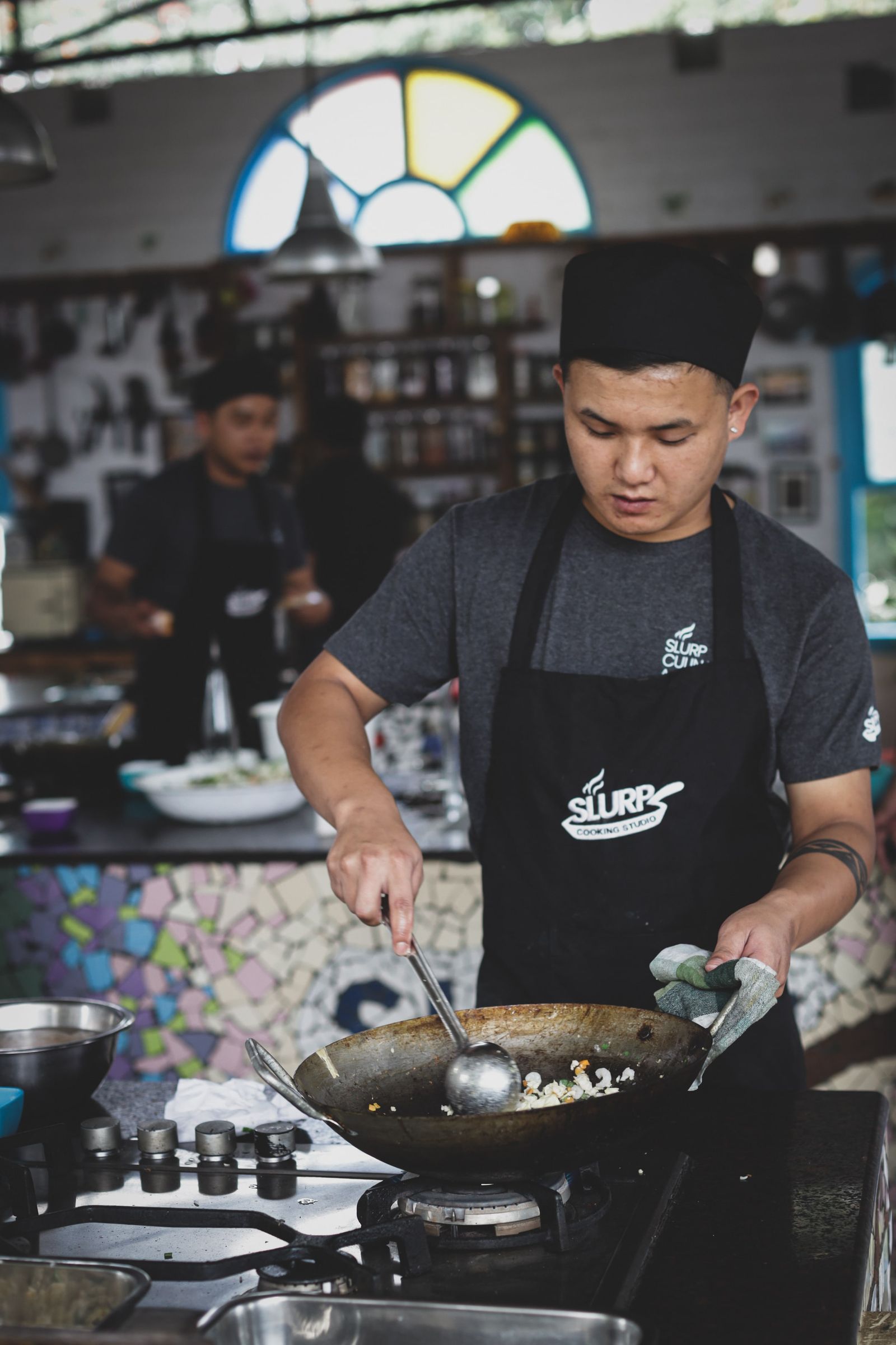 Asian chef cooking in a busy restaurant kitchen