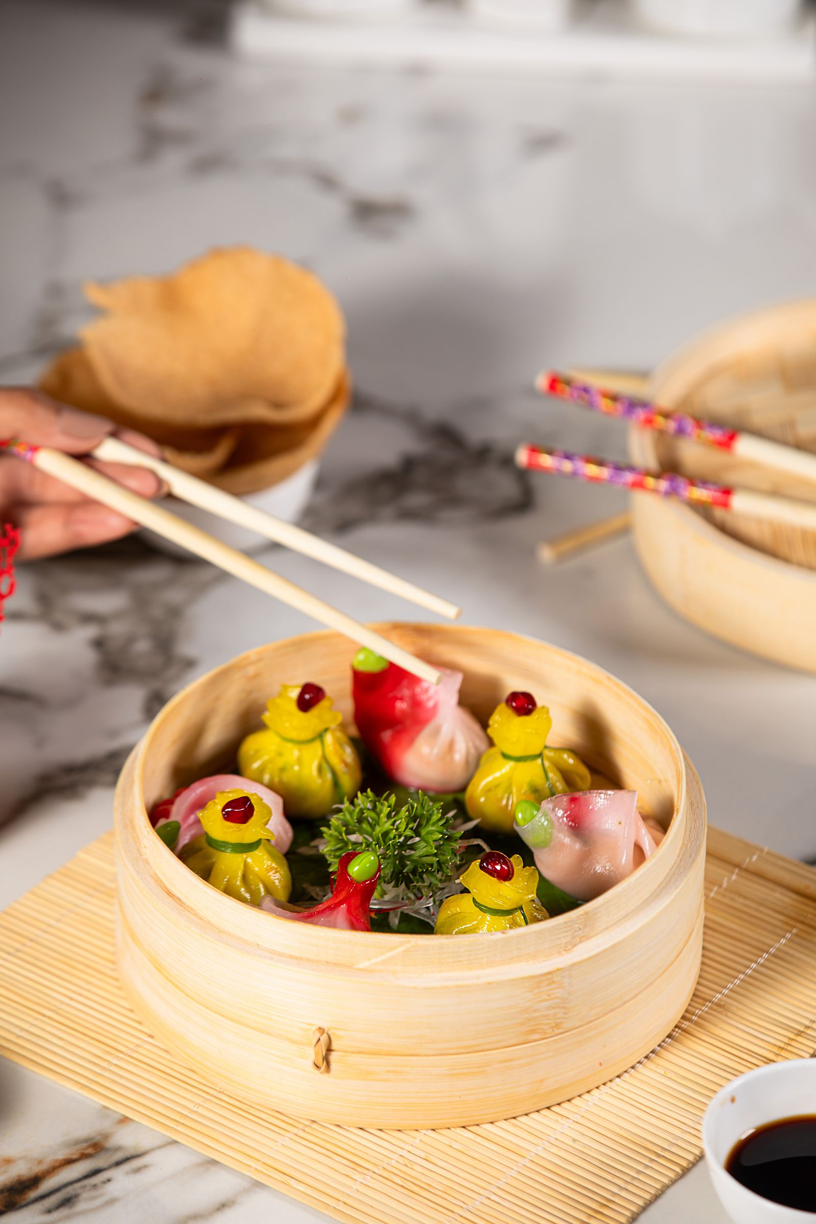 Assorted dumplings in a bamboo steamer with chopsticks