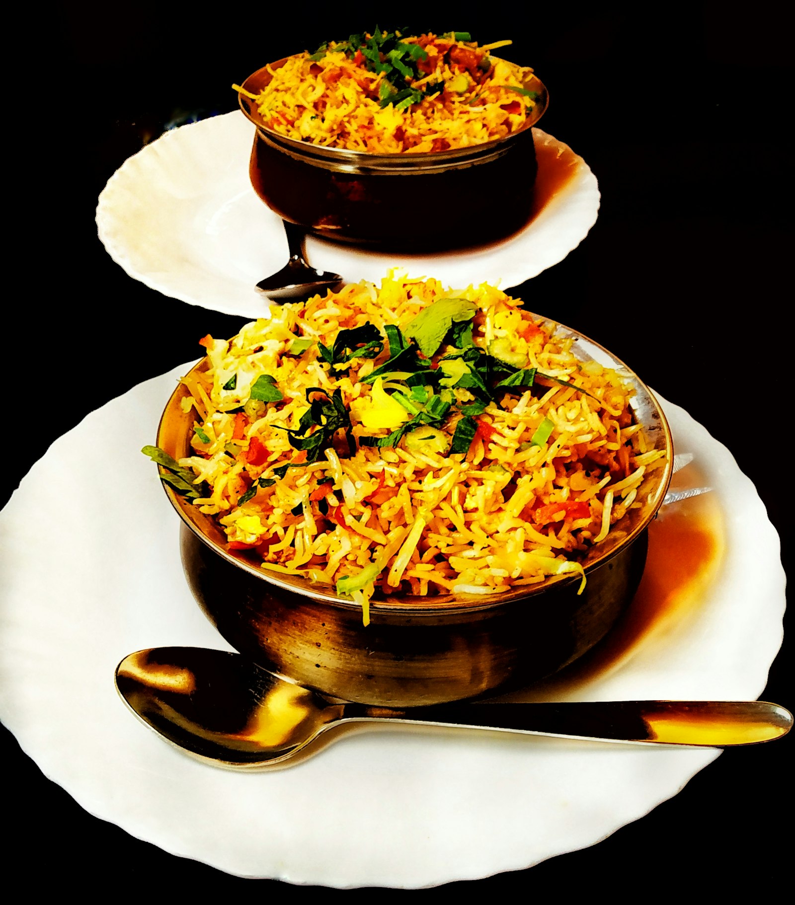 Biryani with meat served on white plates on a dark table