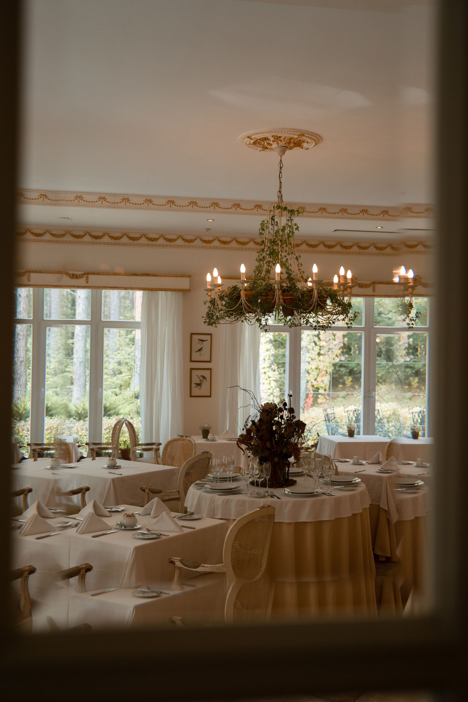 Elegant dining room with a crystal chandelier and set tables