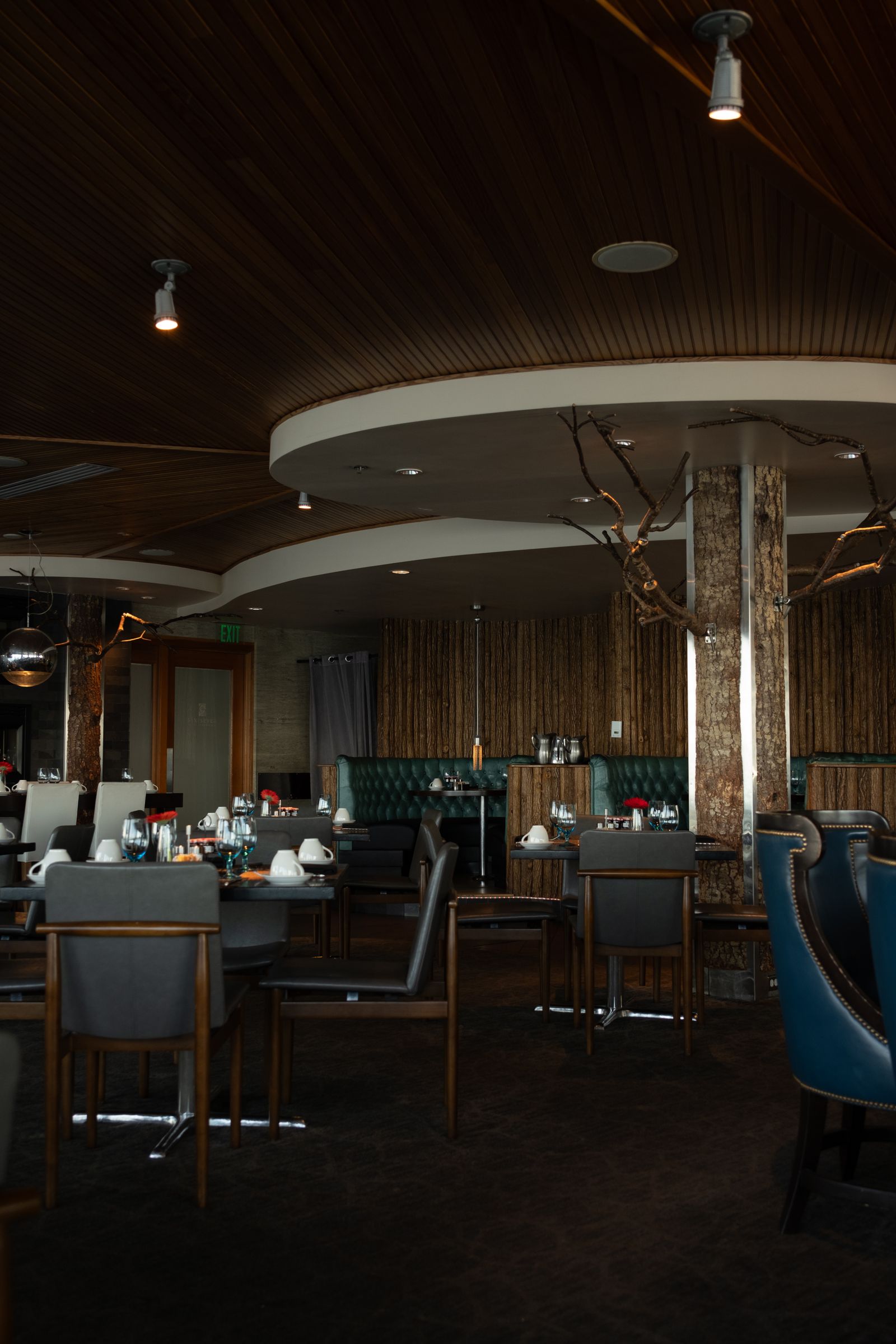 Restaurant dining room with a curved wooden ceiling and soft lighting
