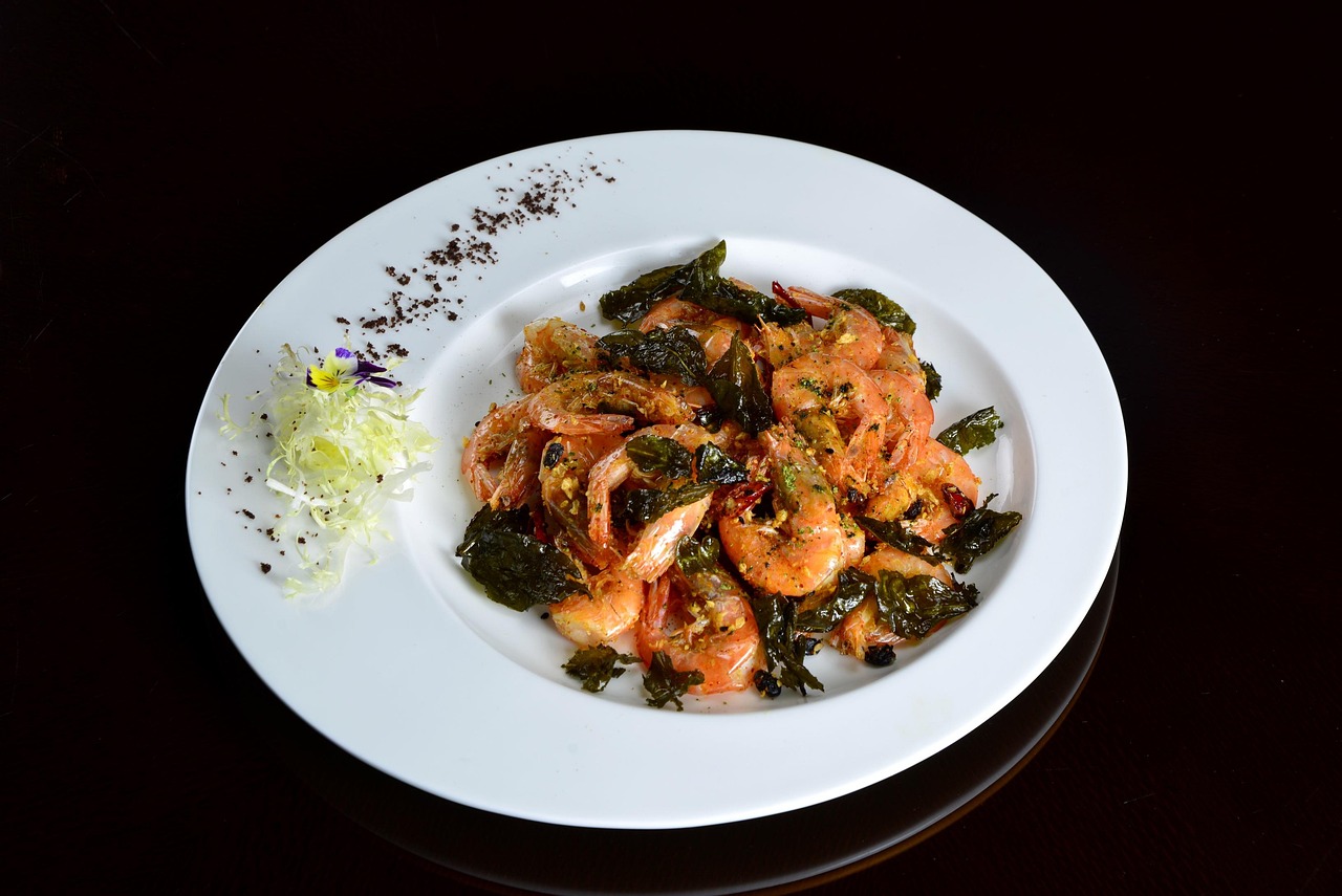 Stir-fried shrimp with greens on a white plate