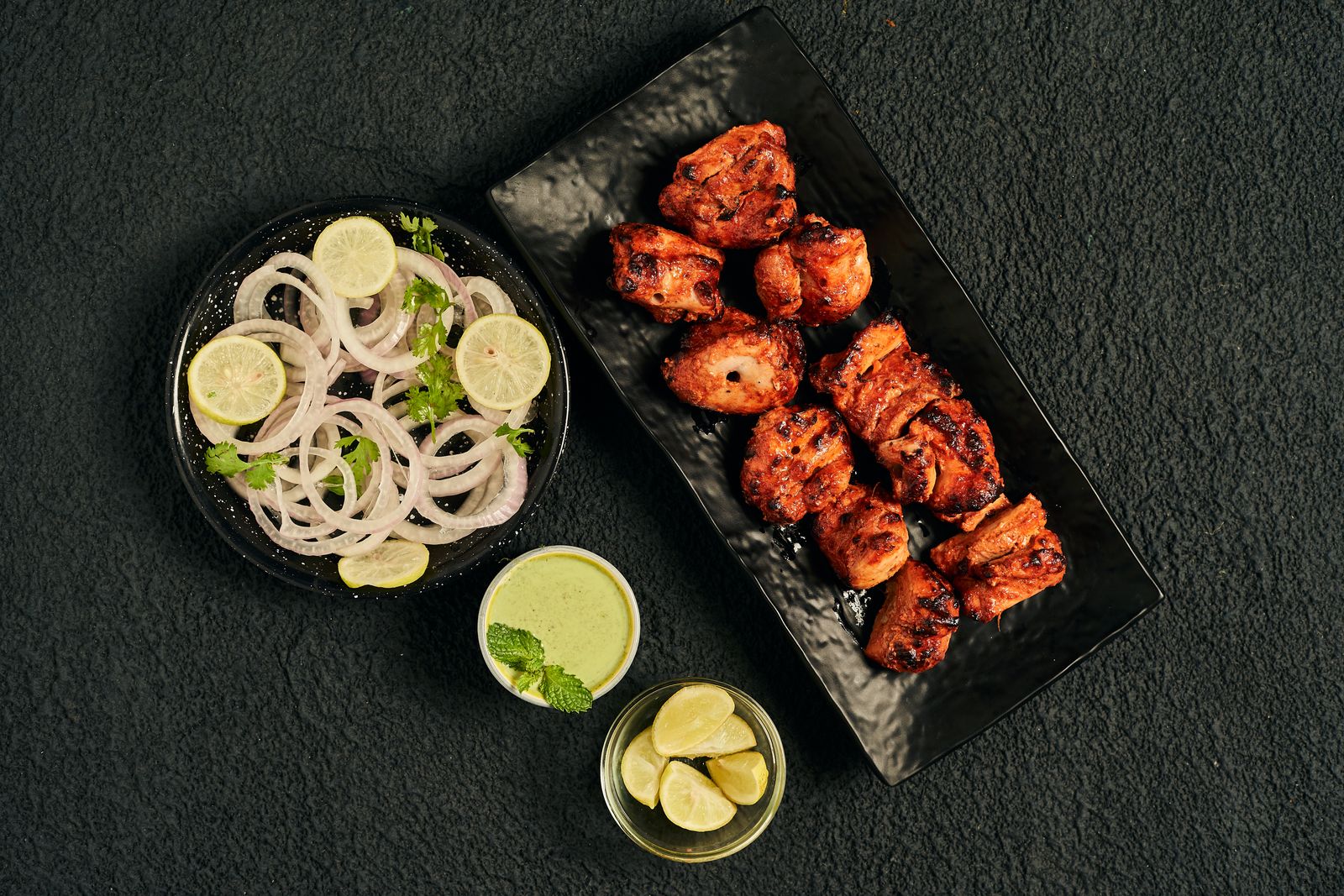 Tandoori chicken pieces with onion salad and green chutney
