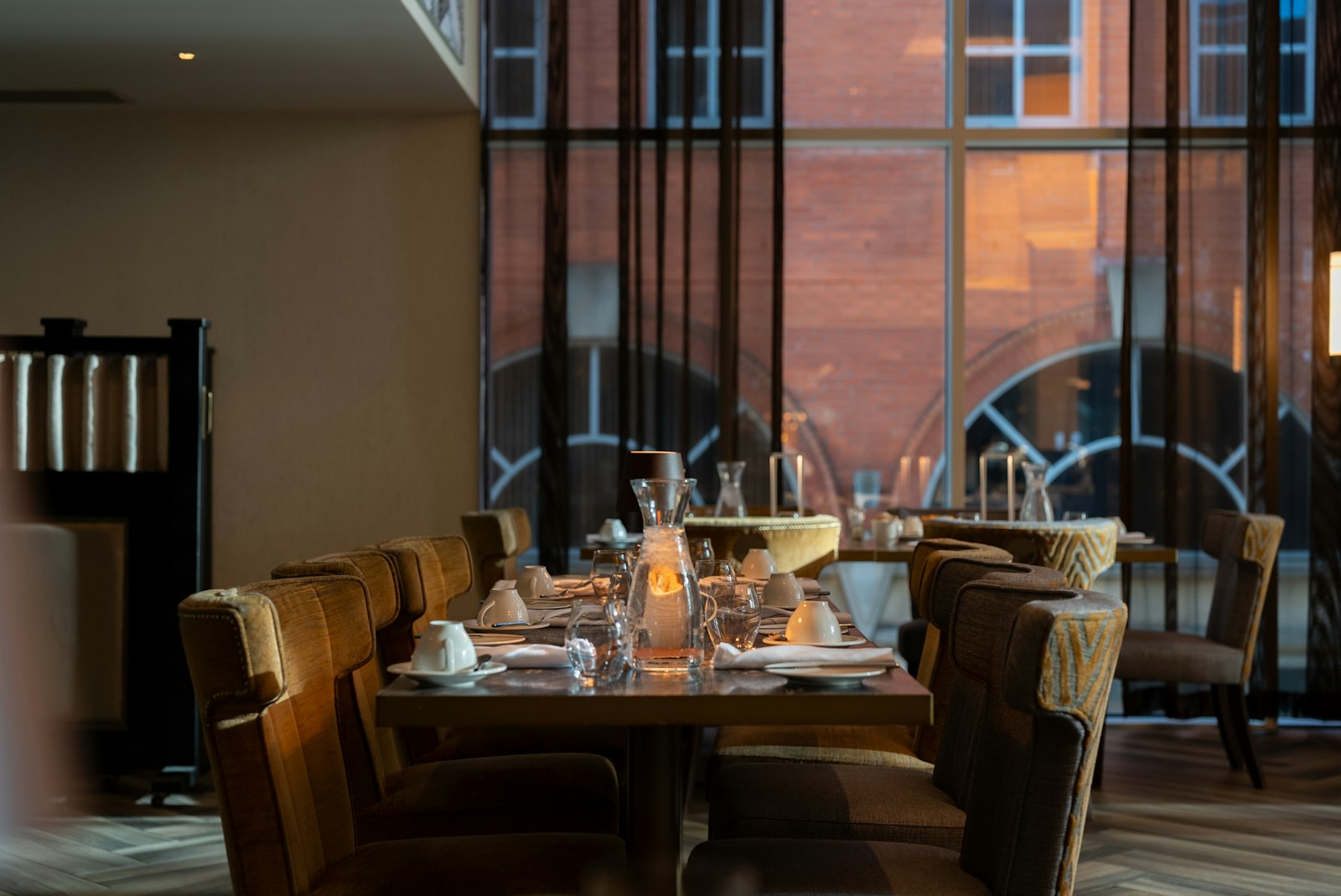 Warm private dining room with long table, chairs and candles